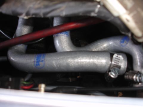 1993 Ford Taurus - Close-up of engine hoses with visible branding and metal clamps.