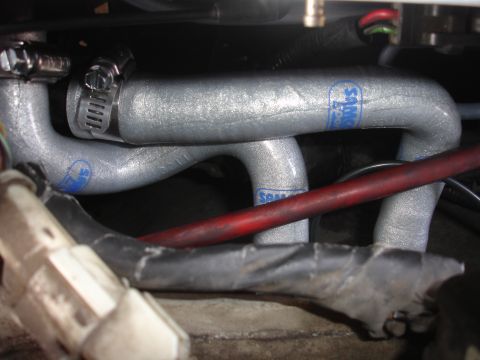 1993 Ford Taurus - Close-up of silver engine hoses with blue 'Samco' branding and a red wire running nearby.