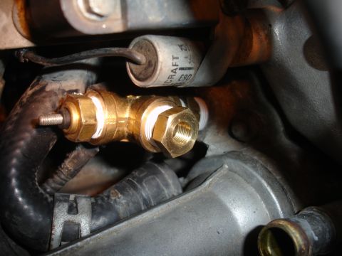 1993 Ford Taurus - Close-up of a brass T-fitting with attached sensor and hoses in an engine bay.