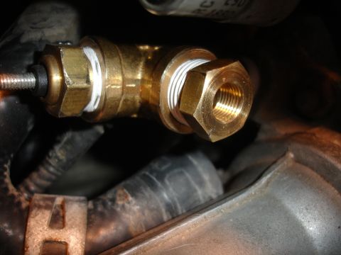 1993 Ford Taurus - A close-up view of a brass plumbing fitting with sealant on the threads.