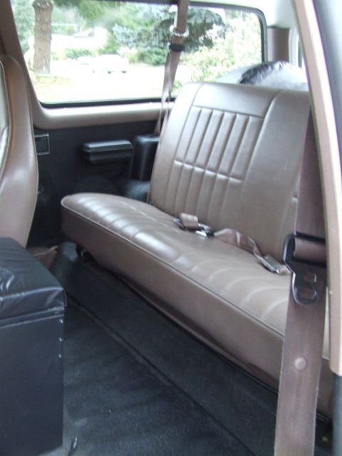 1996 Ford Bronco - Rear interior view of a 1996 Ford Bronco, showing the tan bench seat and seatbelts.