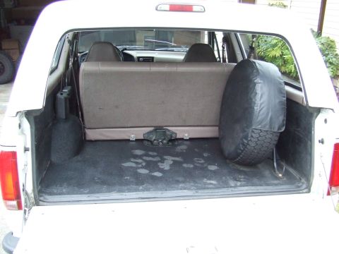 1996 Ford Bronco - Rear cargo area of a 1996 Ford Bronco, a spare tire and fold-down seat.