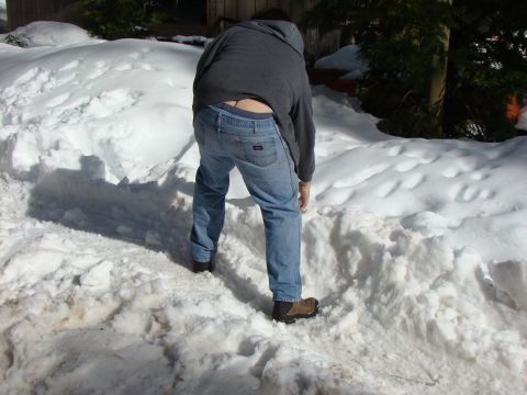 1989 Ford Bronco - A person is bent over in a snowy area, with their back to the camera.