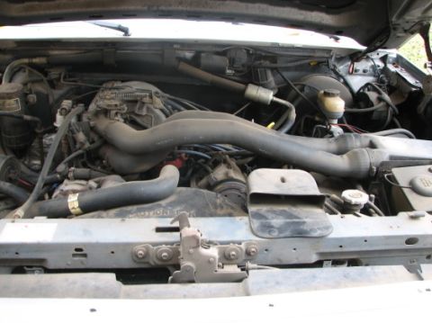 1992 Ford Bronco - The engine bay of a 1992 Ford Bronco shows a V8 engine with various hoses and wiring.