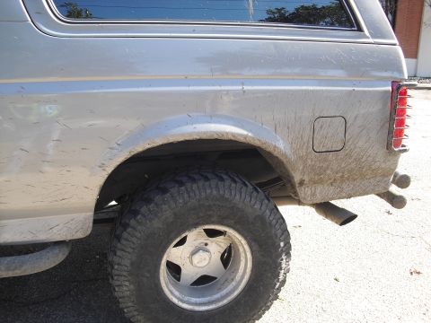 1992 Ford Bronco - Mud streaks mark the side of this 1992 Ford Bronco's rear quarter panel and wheel.