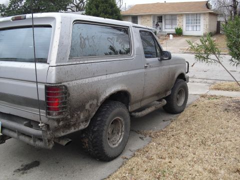1992 Ford Bronco - This 1992 Ford Bronco is seen from the rear quarter angle, heavily coated in mud.