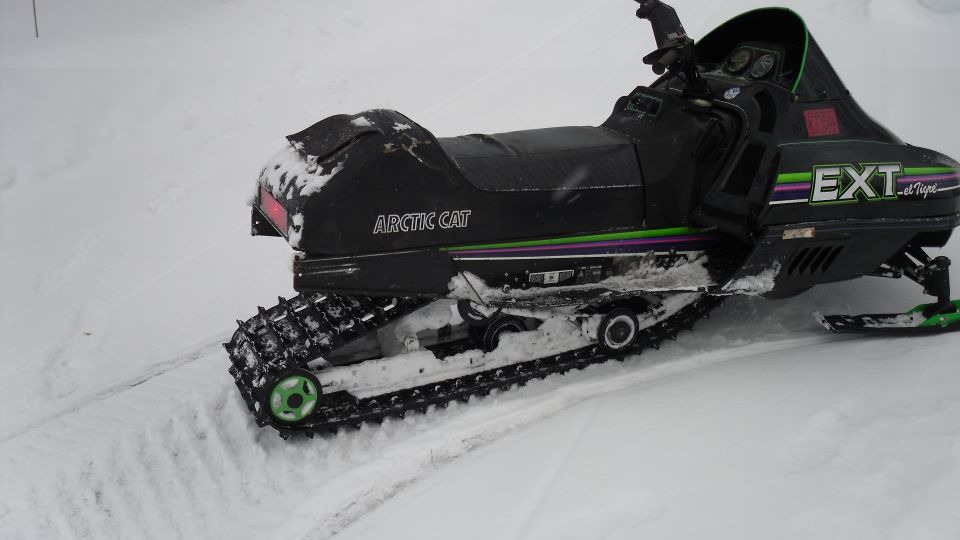 Black Arctic Cat EXT snowmobile parked in snow