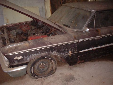 1963 Ford Galaxie - A neglected 1963 Ford Galaxie sits in a garage, showing signs of disrepair and a flat front tire.