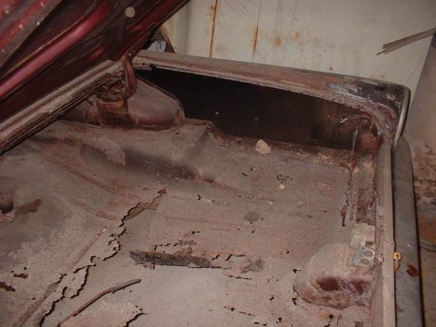 1963 Ford Galaxie - The trunk interior of a 1963 Ford Galaxie shows significant rust and deterioration.