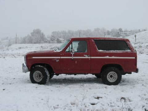 1981 Ford Bronco - A red 1981 Ford Bronco is parked outside during a snowfall.
