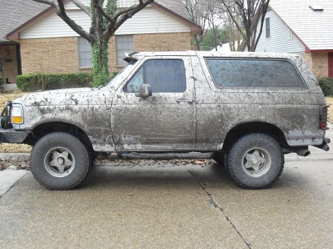 1992 Ford Bronco - This mud-splattered Ford Bronco is parked on a residential street after an off-road excursion.