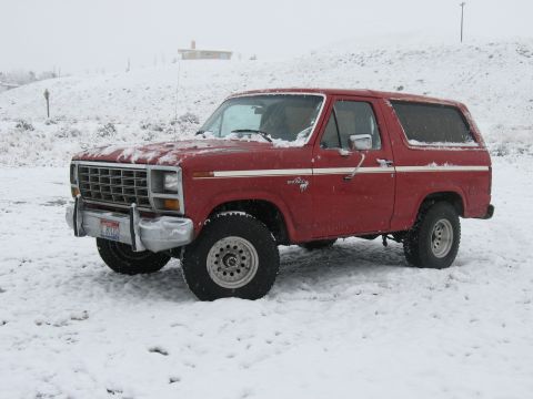 1981 Ford Bronco - A red Ford Bronco sits in a snowy landscape, its body style indicative of the early 1980s.
