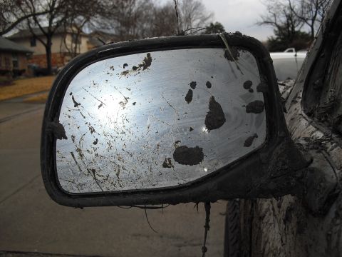 1992 Ford Bronco - Mud covers the side mirror and body of a vehicle after off-roading.