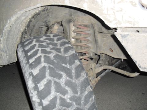 1992 Ford Bronco - The photo shows the wheel well and suspension of a vehicle, with a close-up of the tire tread.