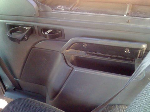 1992 Ford Bronco - Interior door panel of a 1992 Ford Bronco, a cup holder and storage bin.