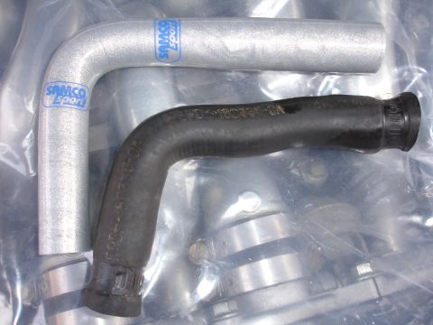 1992 Ford Taurus - Two automotive hoses, one silver aluminum and one black rubber, are shown with "Samco Sport" branding.