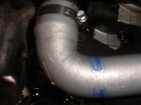 1992 Ford Taurus - A silver engine hose with blue lettering is visible, secured by a metal clamp.