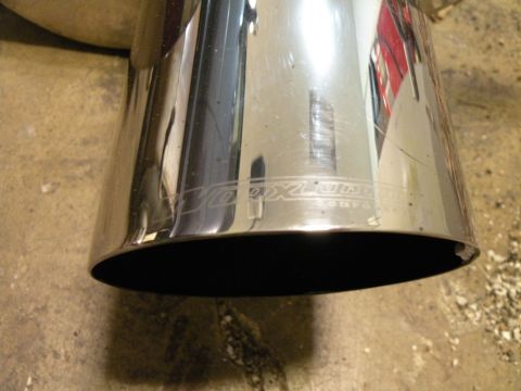 1998 Subaru Legacy - Close-up of a chrome exhaust tip an engraved 'JDM' logo.