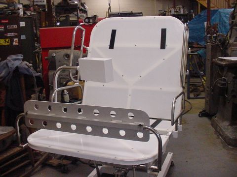 1978 Ford F-250 - A custom-built seat assembly is shown in a workshop environment, with various tools and equipment in the background.