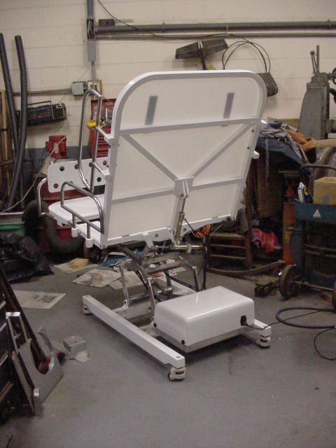 1978 Ford F-250 - A white medical lift chair is shown in a workshop setting with various tools and equipment in the background.