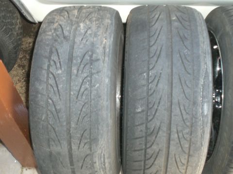 1997 Mercury Cougar - Close-up view of two used tires, showing uneven wear patterns on the tread.