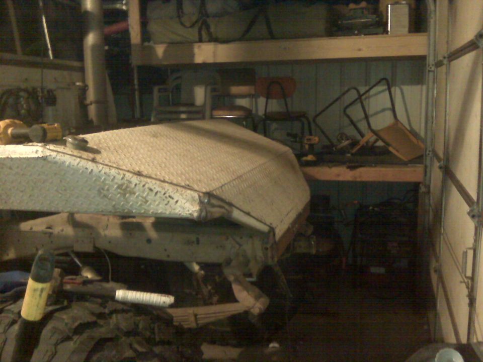 Diamond plate truck bed cap on a vehicle frame with large tires