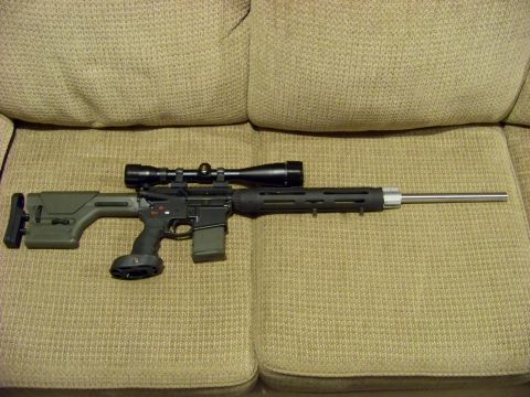 1995 Mercury Grand Marquis - A rifle equipped with a scope and an adjustable stock rests on a textured couch surface.