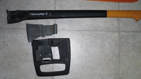 2000 Chevrolet Tahoe - A Fiskars axe and a disassembled car interior component are laid out on a tiled floor.