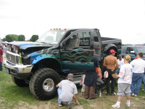 1986 Ford Bronco - Customized Ford F-250 truck on display at an outdoor event with spectators.