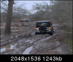 1979 Ford Bronco - Off-road vehicles navigate a challenging muddy terrain on a cloudy day.