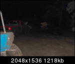 1979 Ford Bronco - A red car is visible at night, with its taillights illuminated.