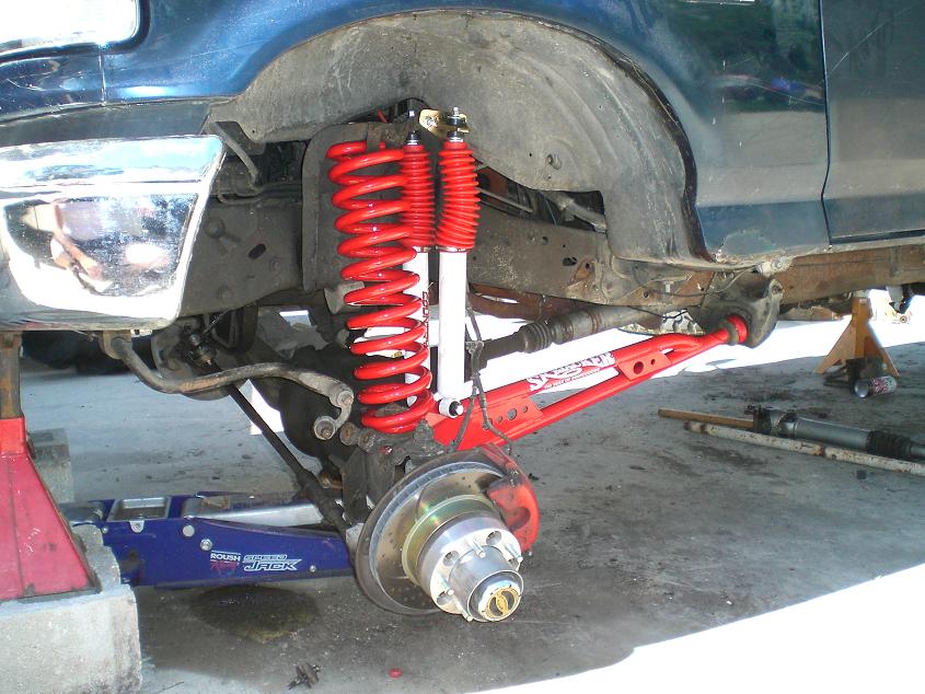 Front suspension of a truck with red coilover shock during work