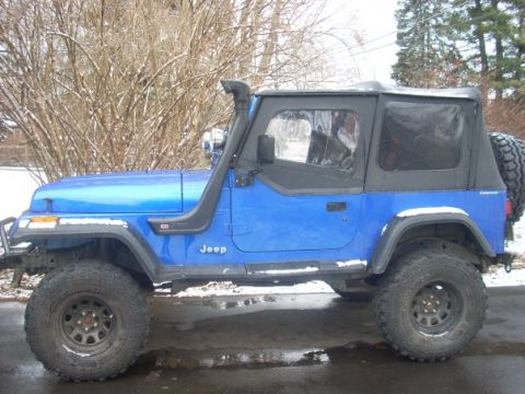 1996 Ford Bronco - A blue Jeep Wrangler is shown from the side, equipped with a snorkel and a soft top, parked outdoors in winter.