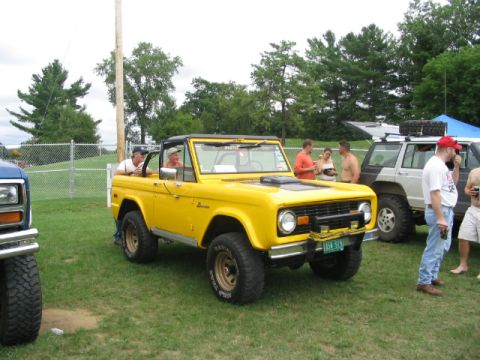 1986 Ford Bronco - Yellow 1986 Ford Bronco at a truck show with other vehicles and people around.