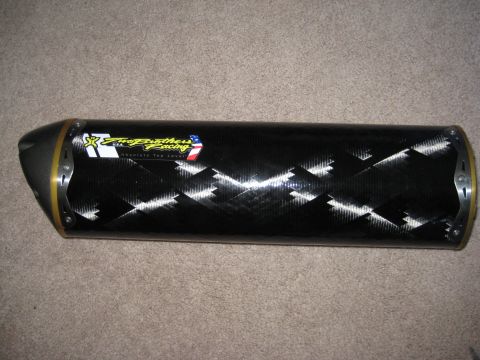 2008 Yamaha FZR1000 - A carbon fiber motorcycle exhaust pipe with a 'Two Brothers Racing' decal is shown on a carpeted surface.