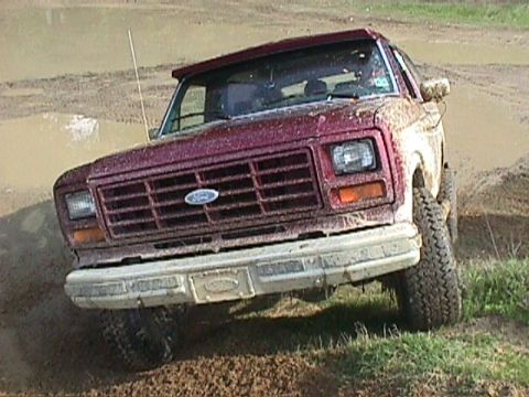 1984 Ford Bronco - This maroon Ford Bronco appears to be from the early 1980s, stuck in a muddy off-road area.