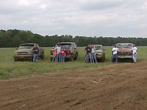 1984 Ford Bronco - A family poses with their red 1984 Ford Bronco in a grassy field.