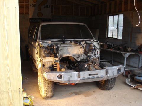 1991 Ford Bronco - A 1991 Ford Bronco is shown in a garage with its front end removed for repairs or modifications.