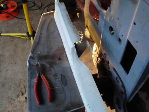 1991 Ford Bronco - A close-up view of a vehicle's frame and a detached bumper piece, with tools nearby.