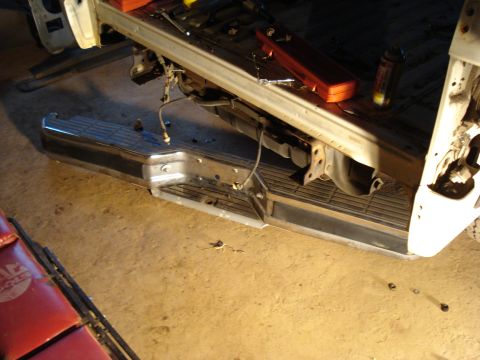 1991 Ford Bronco - This image shows the rear bumper and frame of a vehicle, likely in a workshop setting, with tools visible.