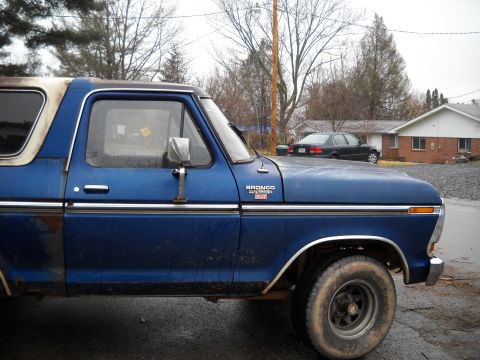 1993 Ford F-150 - A blue 1978 Ford Bronco with a white removable roof is seen from the side.