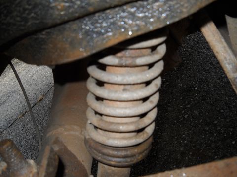 1993 Ford F-150 - Close-up view of a rusty suspension coil spring, likely from a vehicle's undercarriage.