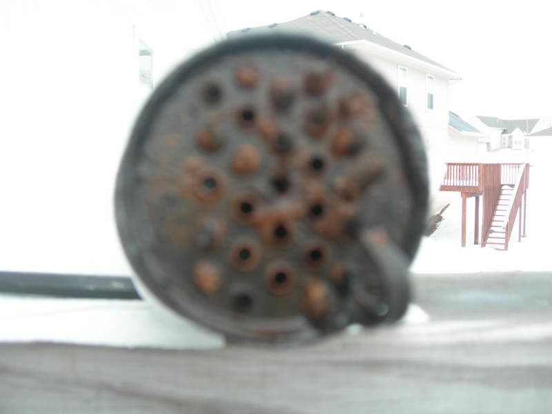 Close-up of a rusty diesel injector with multiple holes