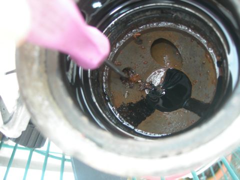 1984 Ford Bronco - Debris and rust are visible inside an engine component during a diesel rebuild.