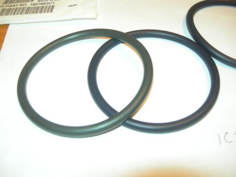 1984 Ford Bronco - Close-up of two rubber O-rings, one dark gray and one black, with a partial label indicating a part number.