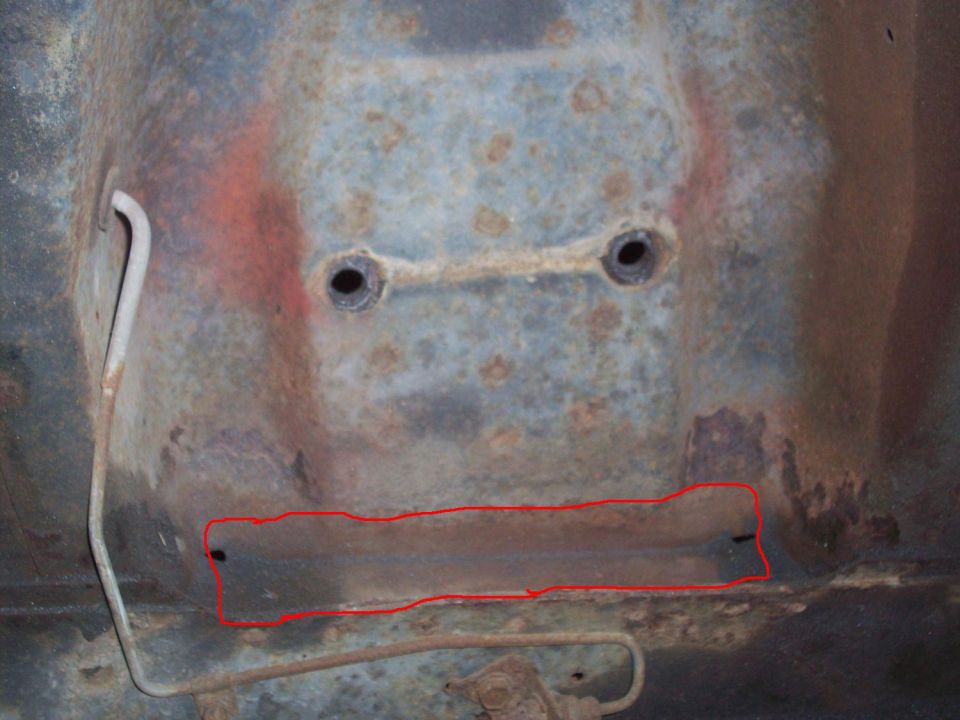 rusted car frame section with two bolt holes and red outline