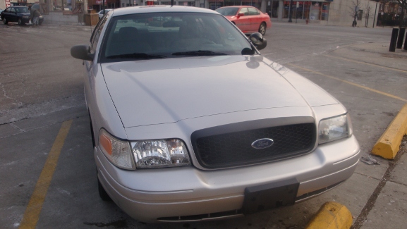 Silver 2005 Ford Crown Victoria parked on street. Front view