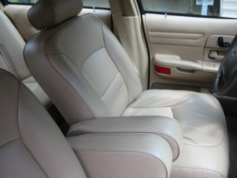 1998 Ford Crown Victoria - Tan leather interior of a 1998 Ford Crown Victoria, focusing on the front seats and door panel.