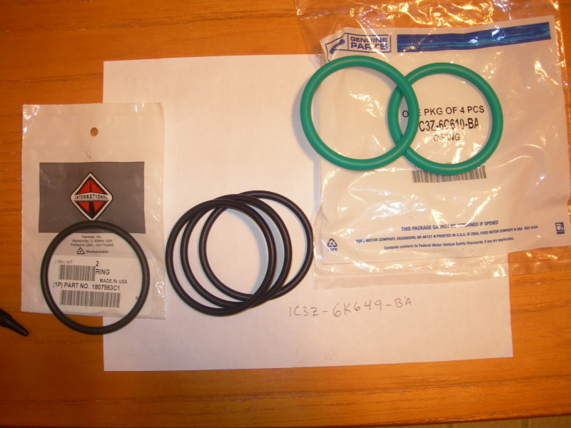 International Harvester logo part bag with o-rings, and another bag with green o-rings. Paper with part numbers is also visible