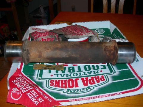 1984 Ford Bronco - Exhaust pipe part shown on a pizza box with work gloves nearby.